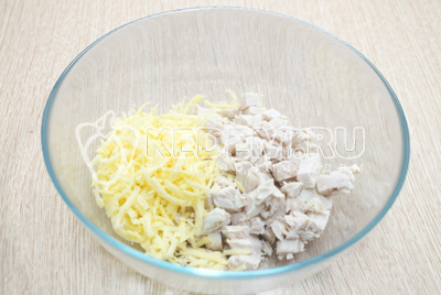 В миску мелко нарезать отварное куриное филе и 100 г сыра натереть на терке.